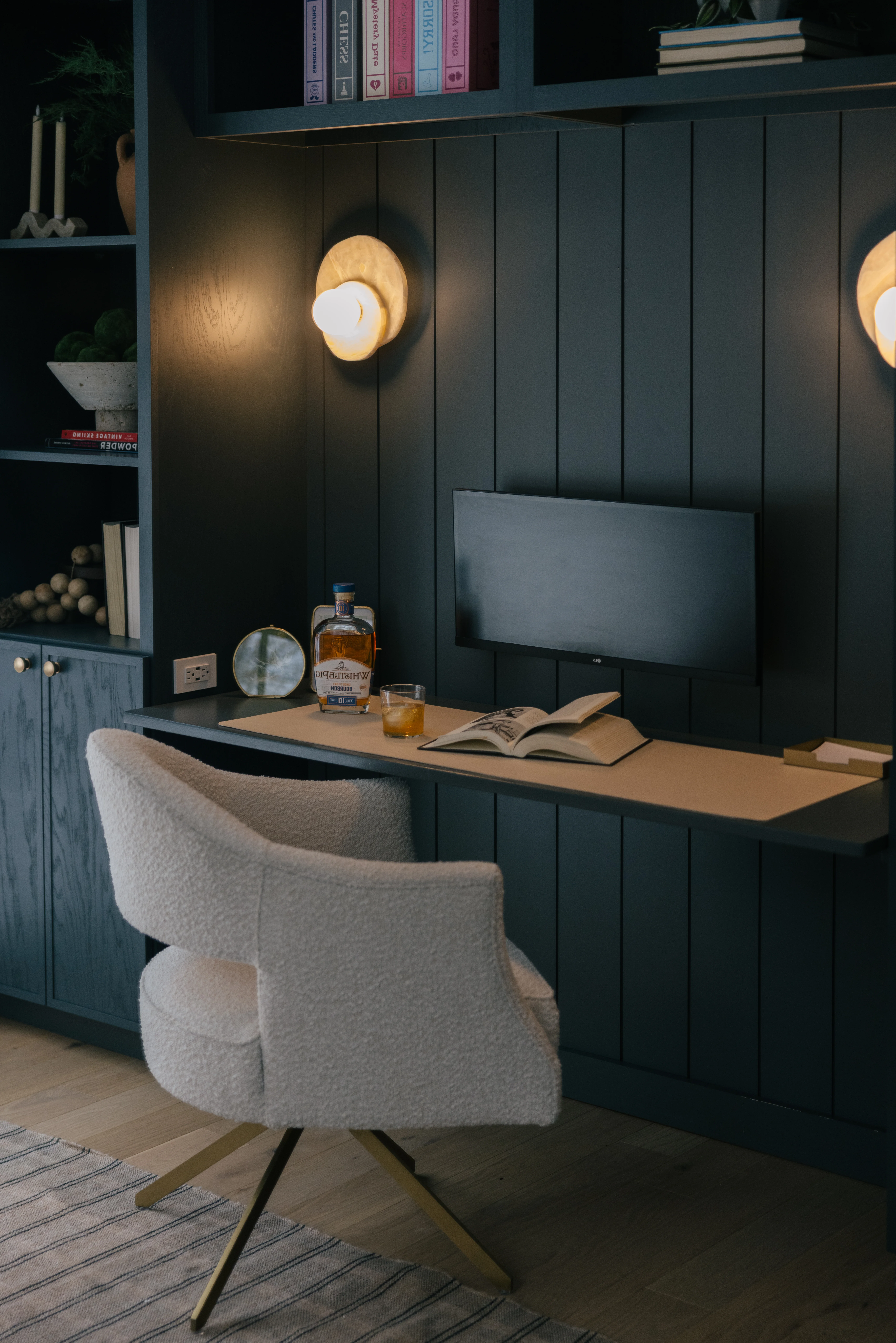 Third angle of the library desk showing the full built-in shelving wall and work area